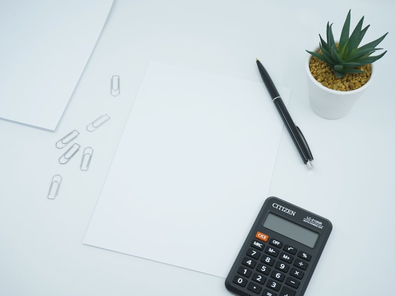 Calculator, pen and paper on a desk