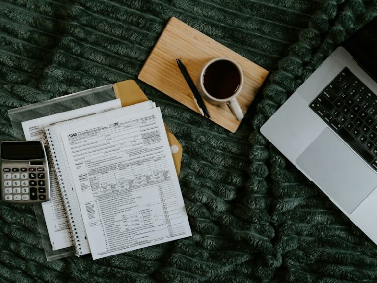 Laptop, papers, calculator and coffee cup on a blanket, representing an SME preparing records for an audit