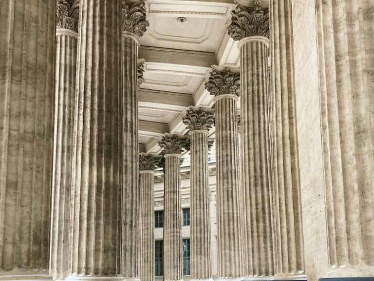 Grey stone columns and steps leading up to a large classical building