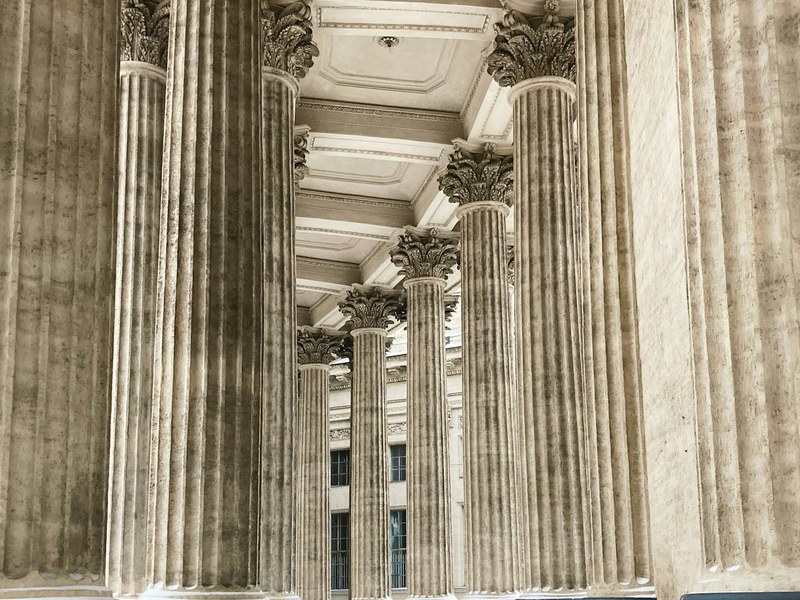 Grey stone columns and steps leading up to a large classical building