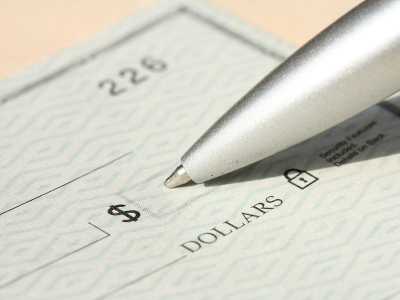 Close-up of a blank cheque with a pen resting near the amount line