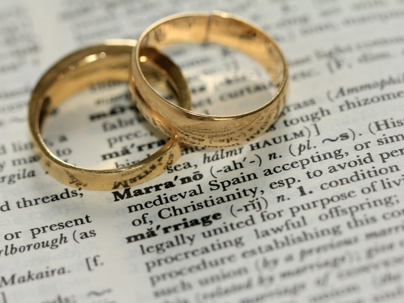 Two wedding rings resting on printed documents