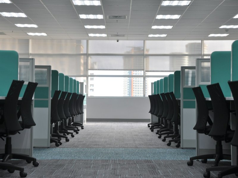 Empty black office chairs at unoccupied cubicle desks