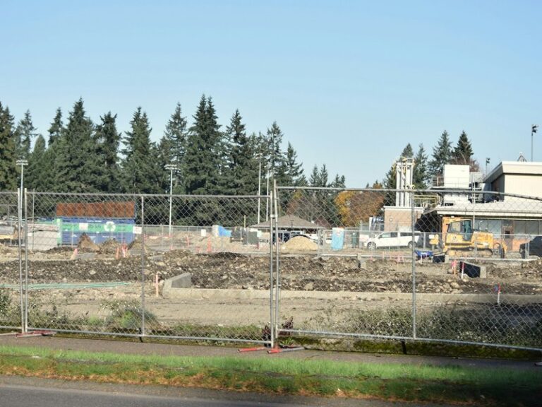 Fenced-off construction site with idle earthworks, illustrating a project halted by a supervening event