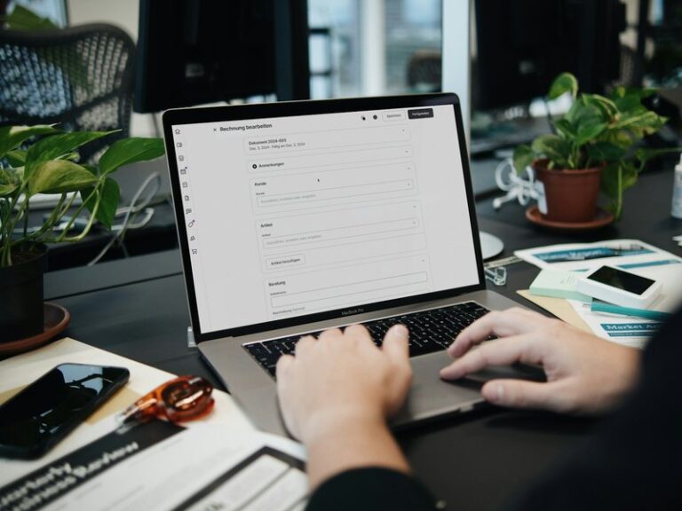 Person editing an invoice on a laptop at an office desk