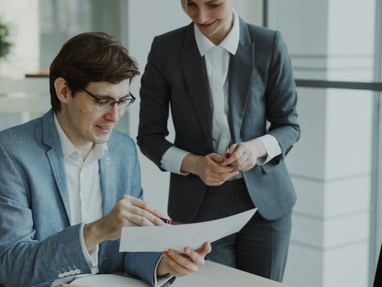 Two business colleagues reviewing a contract document together in an office