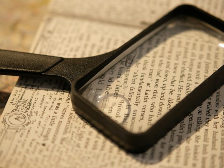 Magnifying glass resting on a page of printed text, representing close scrutiny of statements made before a contract