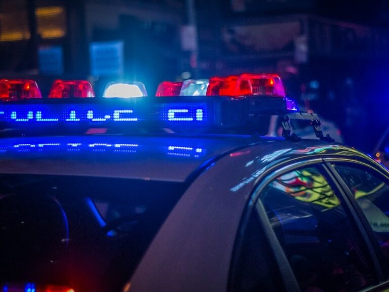 Police car roof light bar glowing red and blue at night