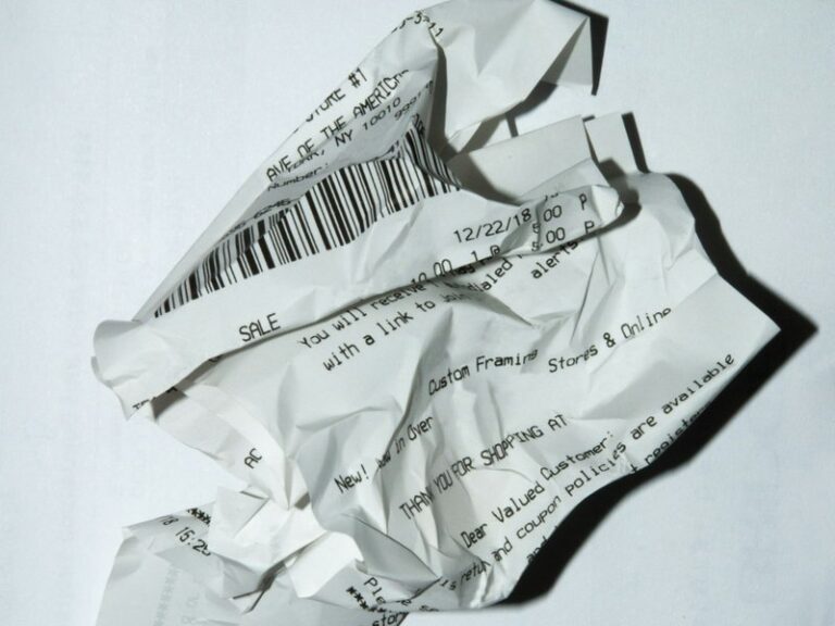 A crumpled shop receipt on a white surface, illustrating business expenses incurred before a company's first sale