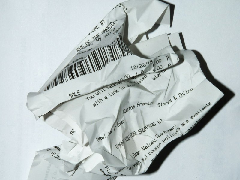 A crumpled shop receipt on a white surface, illustrating business expenses incurred before a company's first sale