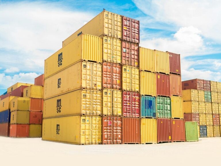 Stacks of coloured shipping containers at a port yard, illustrating cross-border trade and unpaid overseas invoices