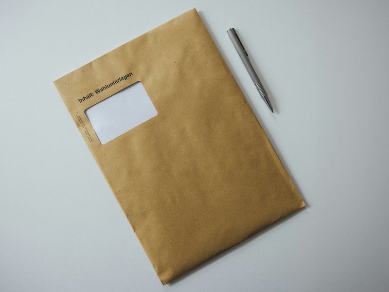 A brown envelope with a pen resting on top, representing court papers delivered to a company's registered office