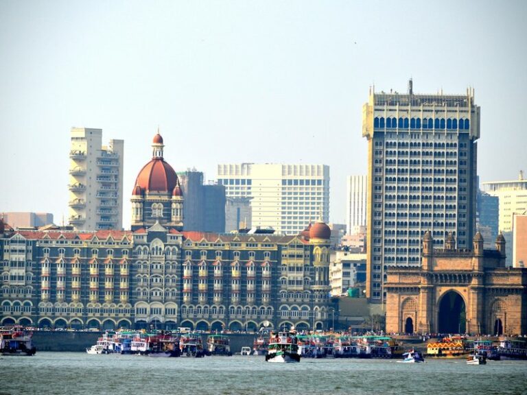 The Taj Mahal Palace hotel and the Gateway of India on the Mumbai waterfront, with ferries in the harbour