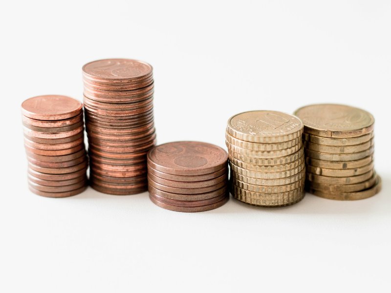 Stacked gold-coloured coins, illustrating company dividends paid to shareholders