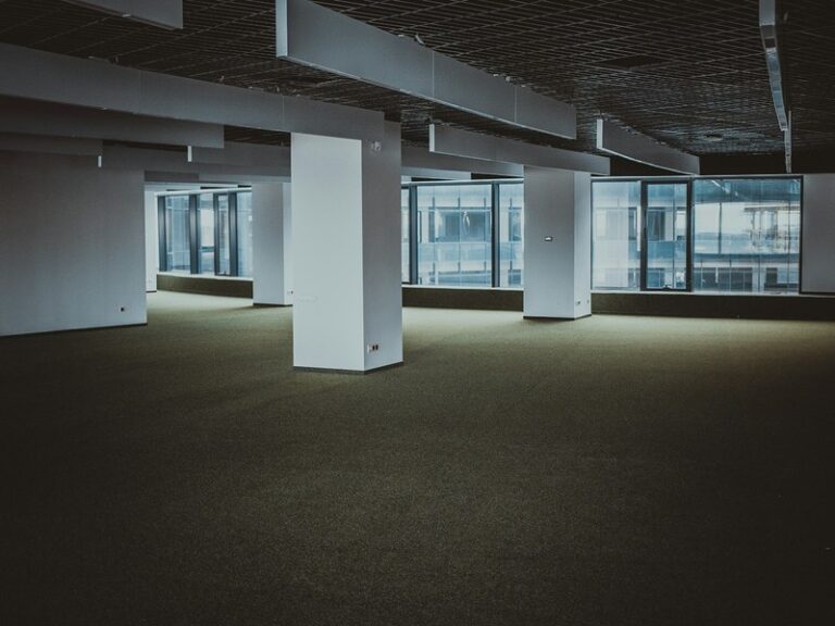 Empty open-plan office floor with pillars and windows, representing vacant leased premises